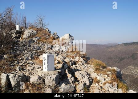 La crête inaccessible du mont Sabotino (Sapotin) domine la vallée étroite de l'Isonzo (Soca).Les poteaux blancs, étroitement plantés, marquent la frontière entre l'Italie et la Slovénie et nous rappellent que dans les années de la Guerre froide, le rideau de fer a couru le long de cette ligne. Banque D'Images