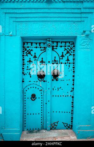 Porte tunisienne traditionnelle en bois bleu vieilli avec ornement dans la ville de Kairouan Banque D'Images