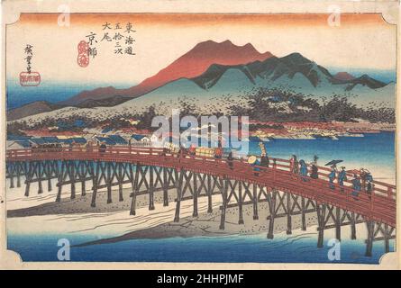 Kyoto : le Grand pont de Sanj ?(Taibi, Keishi, Sanj??hashi), de la série cinquante-trois stations de la T?kaid?(T?kaid?goj?san tsugi).1833–34 Utagawa Hiroshige les voyageurs japonais arrivent finalement au Grand Sanj?Pont sur le fleuve Kamoo à Kyoto, la capitale impériale et le terminal du T?kaid?.En arrière-plan se trouvent des maisons, des temples et des villas au pied de Higashiyama; le mont Hiei, un important centre bouddhiste, est silhoueté à distance.Kyoto : le Grand pont de Sanj ?(Taibi, Keishi, Sanj??hashi), de la série cinquante-trois stations de la T?kaid?(T?kaid?goj?san tsug Banque D'Images