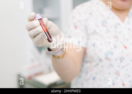 Effectuer un test sanguin sur une veine dans la salle de traitement.L'infirmière pousse une seringue avec une aiguille dans la main du patient.Ecouvillon appuyé contre le Banque D'Images