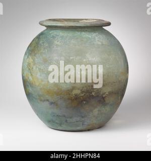 Rte de verre (olla) mi-1st–2nd Century A.D. Roman bleu translucide vert.large, éverté, rebord tubulaire, en repliant, vers l'extérieur, vers le bas, rond et à l'intérieur, avec surface supérieure biseautée; corps ovoïde; fond concave profond.intact, mais avec une fissure interne allant verticalement du bord au sommet du côté; quelques bulles; morcellement, piqûres, dépôt de limpiqué,Faible iridesence, et des intempéries blanchâtres patcheuses sur l'extérieur, l'envasement limy et les intempéries épaisses avec l'iridesence brillante sur l'intérieur.bocal ovoïde Uni.Urne en verre (olla) 245163 Banque D'Images