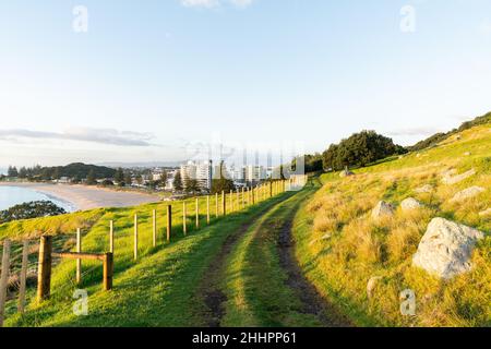 Faites le tour du mont Maunganui le long de la ligne de clôture avec vue sur les bâtiments de la ville et la plage océanique, Tauranga Nouvelle-Zélande. Banque D'Images