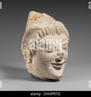 Tête en terre cuite d'une femme d'une statue ca.525–500 B.C. Etruscan tête dans le rond, portant un chapeau pointu, brisé d'une petite statue.Tête en terre cuite d'une femme d'une statue 248595 Banque D'Images