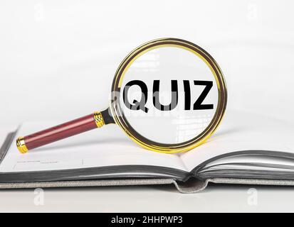 Posez un questionnaire sur la loupe du livre ouvert. Banque D'Images