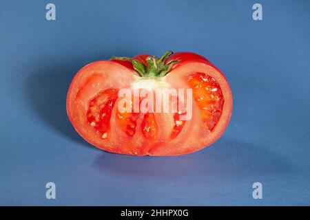 tranches de tomate rose sur fond bleu Banque D'Images