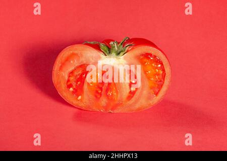 tranches de tomate rose sur fond rouge Banque D'Images