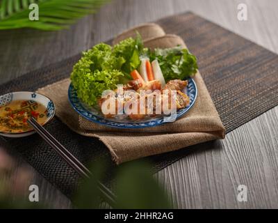 rouleaux de printemps frits dans un plat coloré sur une table en bois Banque D'Images