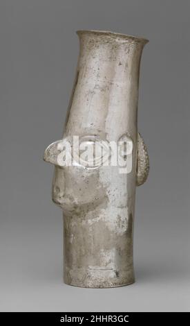 Bécher de face 14th–16th siècle Inca des béchers avec des visages humains d'un côté en métaux précieux ont été travaillés au Pérou du neuvième au début du XVIe siècle.Ceux qui ont des nez prononcés, ressemblant à des chênes d'oiseaux, auraient été trouvés dans de nombreuses parties le long des côtes centrale et sud.Parce qu'aucun n'a été fouillé par les archéologues, leur attribution culturelle est incertaine.Dans la littérature, ils sont appelés Chimú, Chincha, ICA et Inca.Le rendu plus naturaliste des traits du visage sur les béchers Chimú, en particulier les yeux et le nez, se disputerait contre leur attrition Banque D'Images