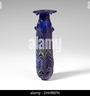 Alabastron en verre (flacon de parfum) fin 4th–début 3rd siècle C.-B. Méditerranée orientale ou sud-italien Bleu cobalt translucide, avec poignées de la même couleur; traînées en jaune opaque, blanc opaque et bleu turquoise opaque.disque à rebord horizontal large, avec repères d'outillage rayonnants sur les surfaces supérieure et inférieure; col cylindrique, effilant vers le haut; épaulement peu profond et inégal;Corps cylindrique droit, légèrement dégressif vers le haut et surface légèrement inégale ; fond convexe légèrement pointu ; sous l'épaule, deux poignées de poignée irrégulières tractées, appliquées sur le motif de traînée.Une fine traînée jaune est fixée à Banque D'Images
