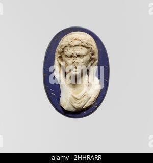 Médaillon de verre de caméo de l'empereur Auguste début du 1st siècle A.D. Roman Matt bleu cobalt, bleu profond, presque opaque et apparaissant noir, et blanc opaque.ovale avec un bord légèrement biseauté, bord rodé, dos plat.Décoration en relief élevé: Buste de l'homme montré frontally, avec front large, oreilles proéminentes, et traits propres-rasés; sur la tête,Couronne et chlamys laurel qui couvrent le haut de la tête et tombe de part et d'autre du cou derrière les oreilles; sous la gorge, tosa pendant en folds.Complete, mais endommagé par la perte du nez et le bon côté droit de la poitrine; terni et piquant, avec de petites taches de faible belette crémeuse Banque D'Images