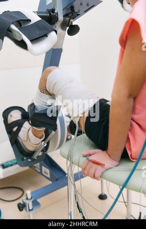 Patient sur des machines à plage de mouvement passive continue.Dispositif permettant un mouvement anatomique correct de la cheville et des articulations.Pied Banque D'Images