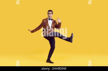 Joyeux gofis jeune homme dans la veste de léopard danse et de s'amuser sur fond jaune Banque D'Images