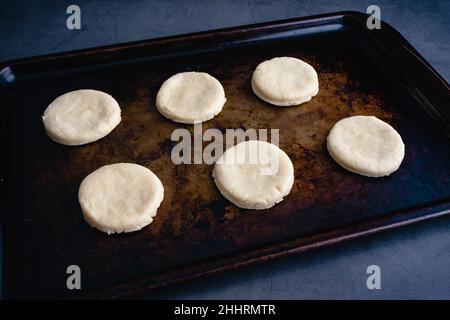 Vue en hauteur des biscuits non cuits sur un poêle à tôle : pâte à biscuits brute découpée sur un moule à pâtisserie en métal Banque D'Images