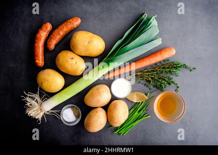 Soupe de poireaux de pommes de terre avec saucisse d'Andouille Ingrédients : légumes frais, saucisse fumée et épices sur fond sombre Banque D'Images