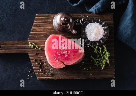 Filet de thon rose sur planche à découper en bois, vue sur le dessus de la table.Steak de poisson non cuit Banque D'Images