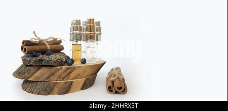 échantillons de parfum sur un support en bois avec de la cannelle sur fond blanc Banque D'Images