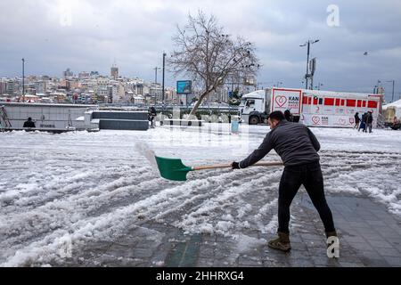 Le 25 janvier 2022 : la neige accumulée devant la route, la chaussée et le magasin couvert de neige a été déblayée par les travailleurs et les équipes municipales.La chute de neige lourde tant attendue a eu un impact négatif sur la vie à Istanbul.Surtout après la forte chute de neige la nuit reliant le 24 janvier au 24th, la vie dans les zones touristiques a commencé à revenir à la normale.(Image de crédit : © Tolga Ildun/ZUMA Press Wire) Banque D'Images