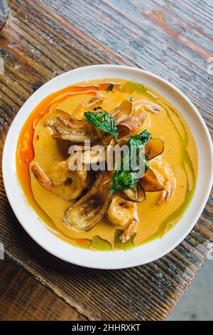 Un plat de curry épicé de crevettes à la noix de coco est servi dans un restaurant thaïlandais Banque D'Images