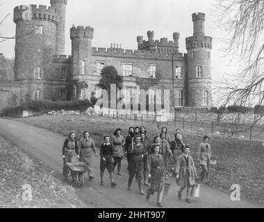 Château de Maesllwch, Radnorshire, pays de Galles, géré par le comité agricole de guerre de Radnor comme auberge pour les filles de terre décembre 1943.Photo : les filles se sont présentées pour une journée de travail, avec le château en arrière-plan. Banque D'Images