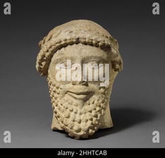 Tête en calcaire d'un mâle barbu avec une couronne de feuilles 2nd quart du 5th siècle C.-B. tête barbu chypriote portant une fronde feuilles.Tête calcaire d'un mâle barbu avec une couronne de feuilles 242386 Banque D'Images