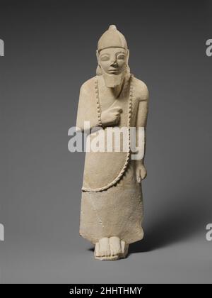 Statuette calcaire d'un votaire mâle probablement mi-6th siècle avant J.-C. chypriote la figure porte un long vêtement et un casque conique.Statuette calcaire d'un votary mâle 242127 Banque D'Images