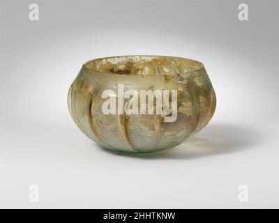 Bol nervuré mi-1st Century A.D. Roman translucide bleu pâle vert.renfoncé, rebord vertical inégal; corps avec côté bombé, puis courbé à fond plat épais.sur le corps, quinze irréguliers, verticaux ribs.Complete mais fissurés; quelques bulles pincées;Le décorticage, le piquage, l'iridescence et les taches d'intempéries laiteuses, avec une zone d'enrobation de sol épais à l'intérieur.c'est un exemple inhabituel du type de bol appelé zarte Rippenschalen puisqu'il n'a pas de rebord extarisé et de col concave.Bol en verre nervuré 245232 Banque D'Images
