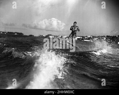 Stirling Moss se mettre en forme en ski nautique sur la plage de Nassau.Il se prépare pour une course de douze heures à Sebring, en Floride, le 12th mars.10th mars 1955. Banque D'Images