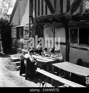 Dans le repos des pèlerins, l'ancienne auberge Tudor à l'extérieur du château de bataille sont 5 enfants qui prennent leur repas à l'école.Ils et leurs camarades d'école y ont leur repas scolaire tous les jours.De gauche à droite, Jane Goodwin 9, Isabelle de Villier-Guimbieu 8, Mary Taylor 5, David Lovelock 7 et Alexander Wagstaff 9.Les enfants sont de l'école gay Bows.Battle, East Sussex, 21st juillet 1954.dans le repos des pèlerins, l'ancienne auberge Tudor à l'extérieur du château de bataille sont 5 enfants qui prennent leur repas scolaire.Ils et leurs camarades d'école y ont leur repas scolaire tous les jours.De gauche à droite, J Banque D'Images