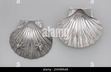 Paire de coquilles Saint-Jacques 1734/35 Paul de Lamerie British dans les premières décennies du XVIIIe siècle, les ménages anglais à la mode ont adopté un goût pour la cuisine française.Les services de dîner d'argent ont été élargis pour accueillir les nouvelles sauces, soupes, gratins et fricassée.Ces coquilles naturalistes peuvent avoir été utilisées pour servir des huîtres, de la sauce ou peut-être du beurre.Paire de coquilles Saint-Jacques 195270 Banque D'Images