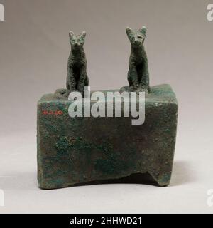 Deux chats surmontant une boîte pour une momie animale 664–30 C.-B. période tardive–période Ptolemaic Bastet était une puissante déesse de la Basse-Égypte, qui était protectrice et pouvait apporter une grande prospérité.En forme de zoomorphique, elle était représentée comme un chat et les chats étaient considérés comme sacrés pour elle.En tant que chat, elle est prête et alerte, sur la garde contre les forces extérieures.Ici, deux chats surmontent une boîte carrée qui aurait une fois tenu une momie d'animal.De telles boîtes de momies ont été déposées dans des catacombes aux côtés de momies de chat recouvertes de lin, comme dans les grandes catacombes de Bubastis et Saqqara.Deux chats surmontant une boîte f Banque D'Images