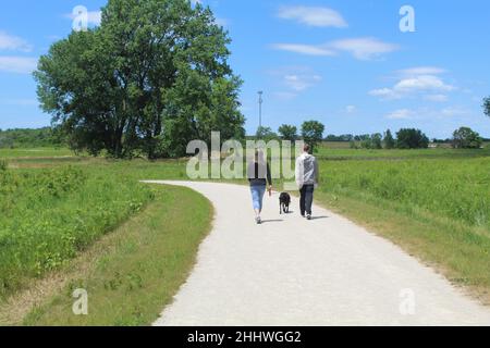 Mère et fils marchant leur chien sur un sentier au parc national James 'Pate' Philip à Bartlett, Illinoi Banque D'Images