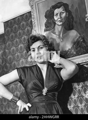 Simone Silva, actrice française, photographiée après un divorce à la maison dans un nouvel appartement, où elle vit coincée entre un garage de réparation et une salle de forage du détachement de l'Artillerie royale, Londres, 21st février 1954. Banque D'Images