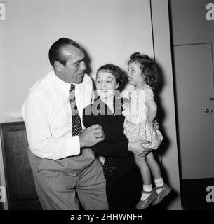 Primo Carnera, Wrestler, ancien boxeur, avec Peggy Brindle et sa fille Susan, de New York, Etats-Unis.Il a aidé à financer le traitement médical de Susan au Royaume-Uni, elle est née prématurée et aveugle, et n'a pas pu être aidée en Amérique.Mme Brindle a envoyé Susan au Royaume-Uni il y a 18 mois.Depuis lors, les chirurgiens de l'hôpital de Moorfield à Londres ont donné à Susan une vue parfaite dans son œil gauche et espèrent réparer l'œil droit sans visibilité.Sur la photo, Susan rencontre son bienfaiteur pour la première fois à son hôtel, Kensington, Londres, 6th septembre 1954. Banque D'Images