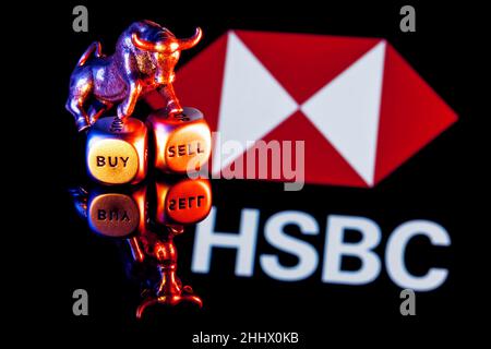 Un taureau métallique se dresse sur des dés d'achat-vente sur le fond du logo de la banque HSBC Banque D'Images