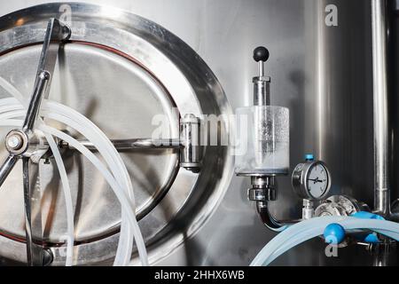 Équipement pour la production de bière artisanale, récipients de fermentation dans la chambre climatique, manomètre à tubes et réservoirs en acier inoxydable. Banque D'Images