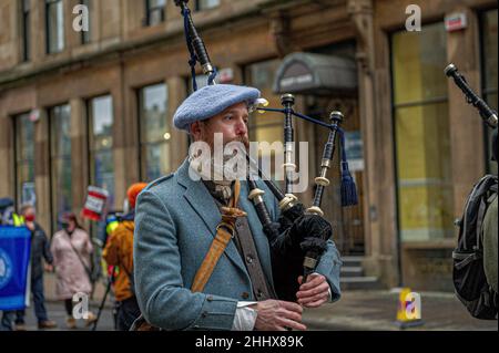 Glasgow, Royaume-Uni.22nd janvier 2022.Un joueur de cornemuse est vu en direction de la marche dans la rue.1 000 partisans sont venus en faveur de l'indépendance écossaise suite à la nouvelle que le Premier ministre britannique, Boris Johnson, a organisé de nombreuses fêtes et réunions au 10 Downing Street pendant les serres du coronavirus malgré les lois et les projets de loi introduits pour freiner la propagation du virus.Crédit : SOPA Images Limited/Alamy Live News Banque D'Images