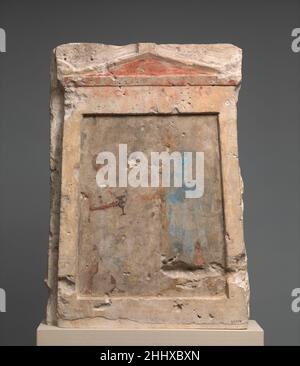 Panneau funéraire en calcaire peint avec un soldat prenant un kantharos de son accompagnateur 2nd moitié de 3rd siècle avant Jésus-Christ grec Un garçon à la peau brun foncé, debout à gauche, tient une tasse noire à un grand soldat dans un long manteau bleu, à droite.Le garçon tient une lance et soutient le grand bouclier ovale du soldat contre sa poitrine.Presque toutes les preuves conservées pour la peinture dans la période hellénistique viennent de monuments funéraires.Certains comme les tombeaux voûtés de Macédoine et Thrace montrent des figures et des frises à grande échelle.Plus modeste stelai peint comme ceux affichés ici ont été trouvés dans Banque D'Images