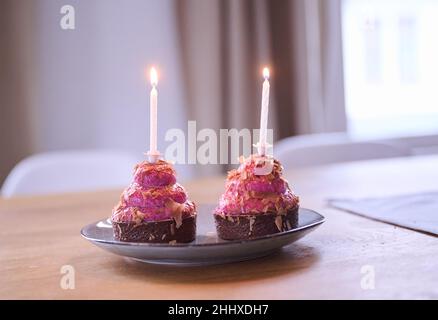 Berlin, Allemagne.12th janvier 2022.ILLUSTRATION - deux cupcakes avec bougies allumées sont placés sur une table.(Scène posée) Credit: Annette Riedl/dpa/Alay Live News Banque D'Images