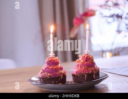 Berlin, Allemagne.12th janvier 2022.ILLUSTRATION - deux cupcakes avec bougies allumées sont placés sur une table.(Scène posée) Credit: Annette Riedl/dpa/Alay Live News Banque D'Images