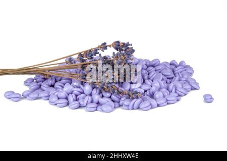 Gouttes de cire violette et lavande pour l'épilation à la cire isolées sur le blanc Banque D'Images