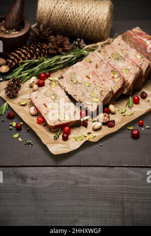 Terrine française traditionnelle en tranches recouverte de bacon sur fond de bois sombre Banque D'Images