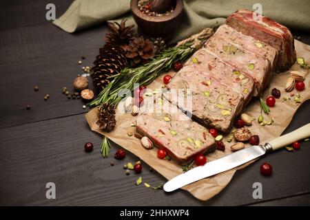 Terrine française traditionnelle en tranches recouverte de bacon sur fond de bois sombre Banque D'Images