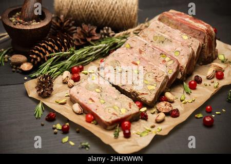 Terrine française traditionnelle en tranches recouverte de bacon sur fond de bois sombre Banque D'Images