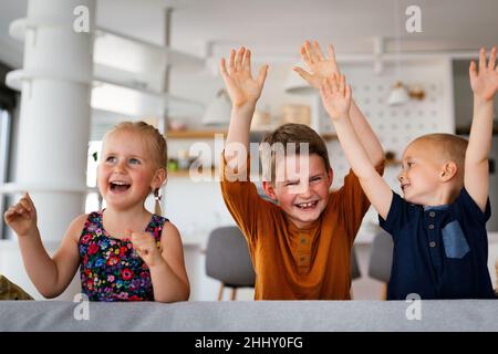 Groupe de petits enfants s'amusant et souriant ensemble à l'intérieur. Banque D'Images