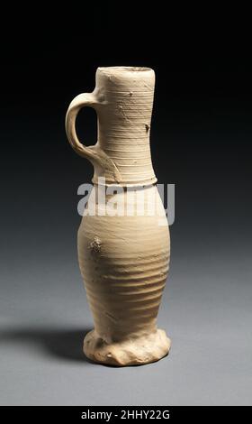 Carafe fin 14th–début 15th siècle allemand le cou et le corps de cette carafe mince et sans bec ont été tournés séparément.Le fabricant a fait le combed dans les rainures et les lignes horizontales pendant que le navire était sur la roue et a travaillé la poignée et la peseuse pincée pied à la main.La surface crémeuse et non vitrifiée est typique du grès médiéval produit à Siegburg, près de Cologne, en utilisant l'argile locale abondante, qui est presque blanche.Les céramiques de Siegburg ont été largement exportées vers les îles néerlandaises et britanniques.Verseuse 671535 Banque D'Images