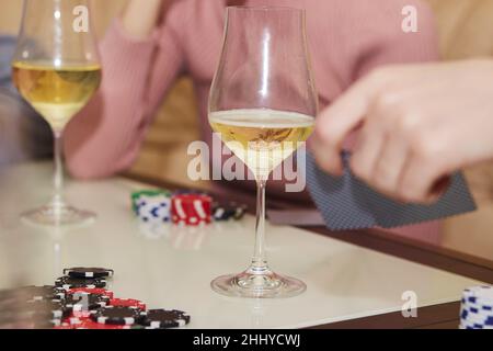 Joueurs de poker avec jetons et cartes gros plan.Verres de champagne.Concept de jeu.Moment sincère.Mise au point sélective. Banque D'Images