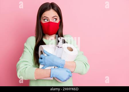 Portrait de fille de brunette look vide espace tenir papier toilette bouteille dans le supermarché porter masque gants lime chandail isolé sur la couleur rose Banque D'Images