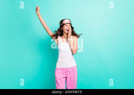 Photo d'adorable vêtements de nuit doux pour jeune femme bâillements isolés couleur bleu sarcelle arrière-plan Banque D'Images