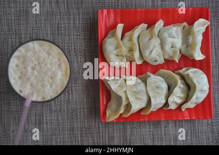 Vue de dessus de veg momos (boulonnage népalais) avec lassi sur fond gris Banque D'Images