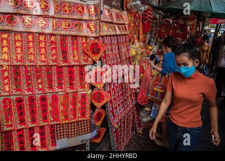 Une femme portant un masque facial a vu passer le magasin chinois de décorations du festival du nouvel an lunaire dans le quartier chinois de Chinatown à Bangkok.l'Administration métropolitaine de Bangkok (BMA) a ordonné d'annuler les célébrations publiques du nouvel an lunaire chinois dans le quartier chinois de Chinatown à Bangkok pour empêcher la propagation du coronavirus COVID-19,Cependant, ils permettent aux gens de participer à des rituels et à des traditions dans le cadre de mesures de santé.Le nouvel an lunaire chinois est marqué le 01 février 2022, et marque également le début de l'année du tigre.(Photo de Peerapon Boonyakiat/SOPA Images/Sipa USA) Banque D'Images